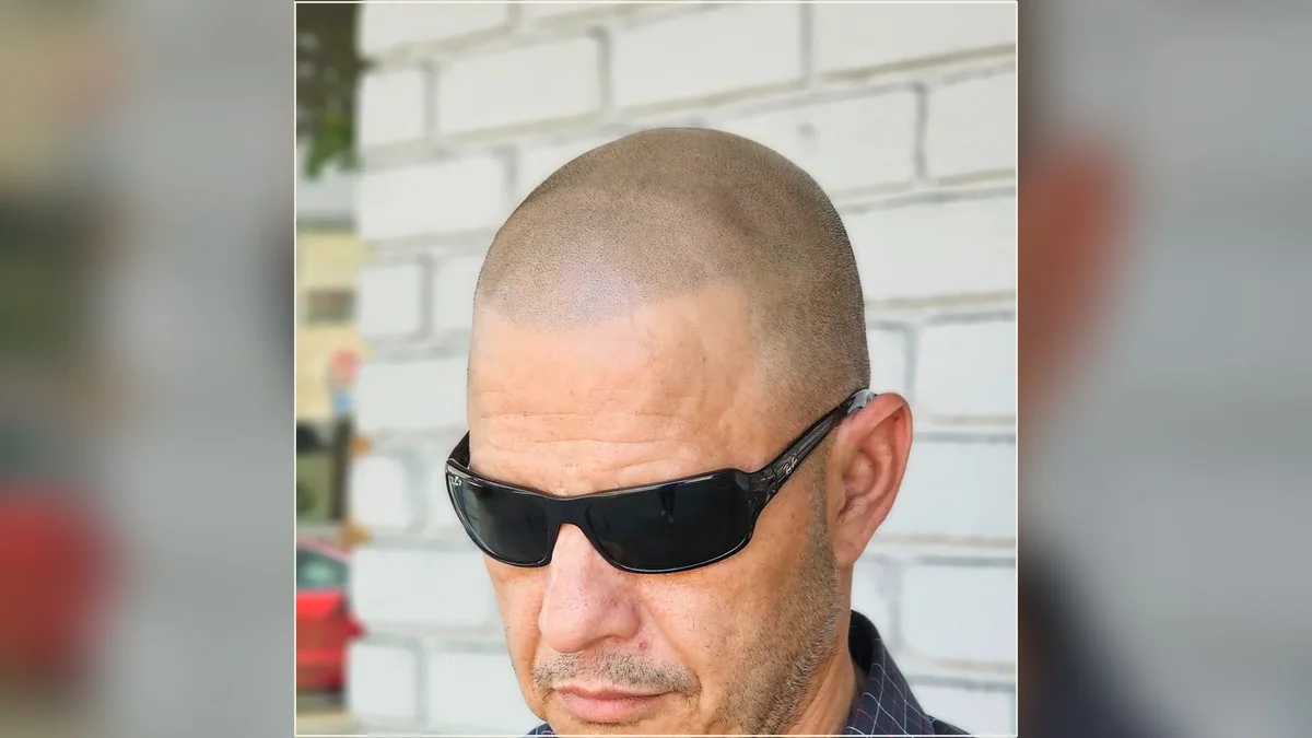 A HairDot.Ink website photograph of a man wearing sunglasses outdoors