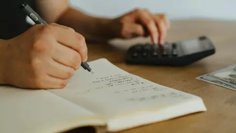 A notebook and calculator used to plan a budget
